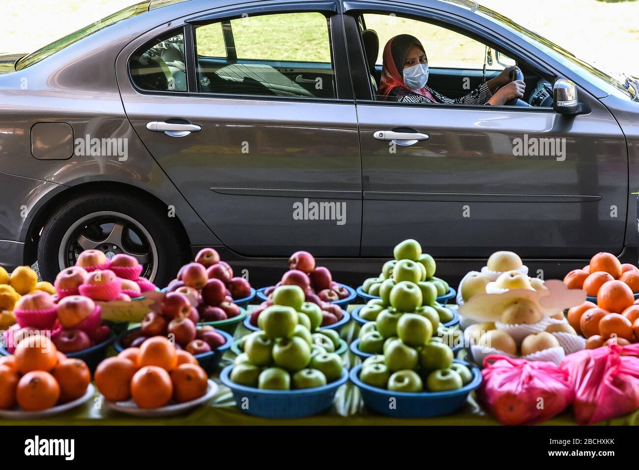 Seremban, Negeri Sembilan, MALAYSIA. April 2020. Eine Frau betrachtet Früchte, die auf einem Markt für Durchfahrt-Landwirte in Seremban, Malaysia, verkauft werden. Die Regierung von Malaysia hat am 18. März einen Befehl zur Bewegungskontrolle zur Bekämpfung der Verbreitung von COVID-19 erlassen, in dem nur wesentliche Dienste für den Betrieb zugelassen sind. Kredit: Fuad Nizam/ZUMA Wire/Alamy Live News Stockfoto