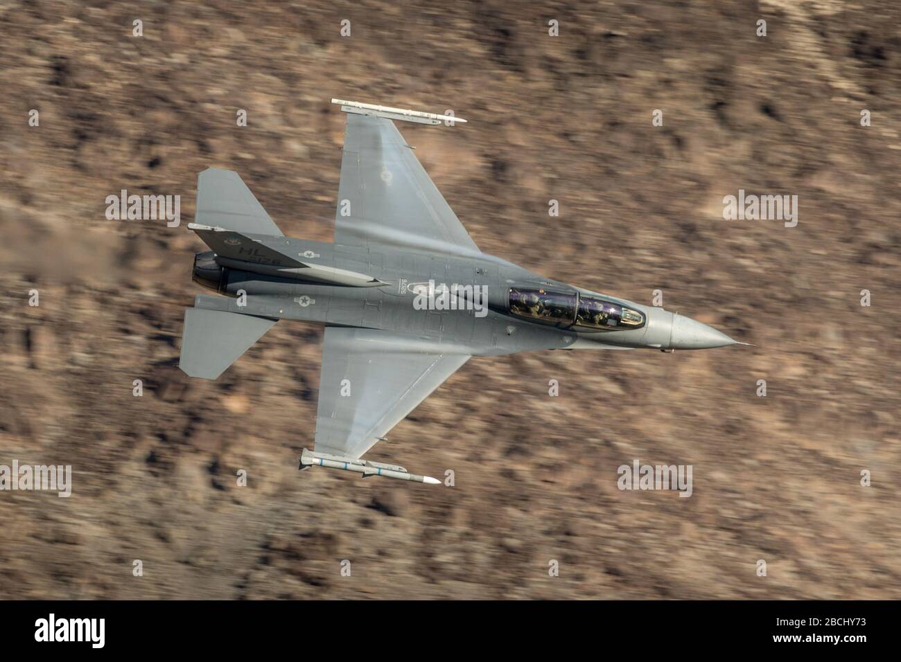 United States Air Force (USAF) General Dynamics F-16 Kampf Falcon Fighter Jet von Edwards AFB fliegen auf niedriger Ebene in Death Valley Kalifornien. Stockfoto