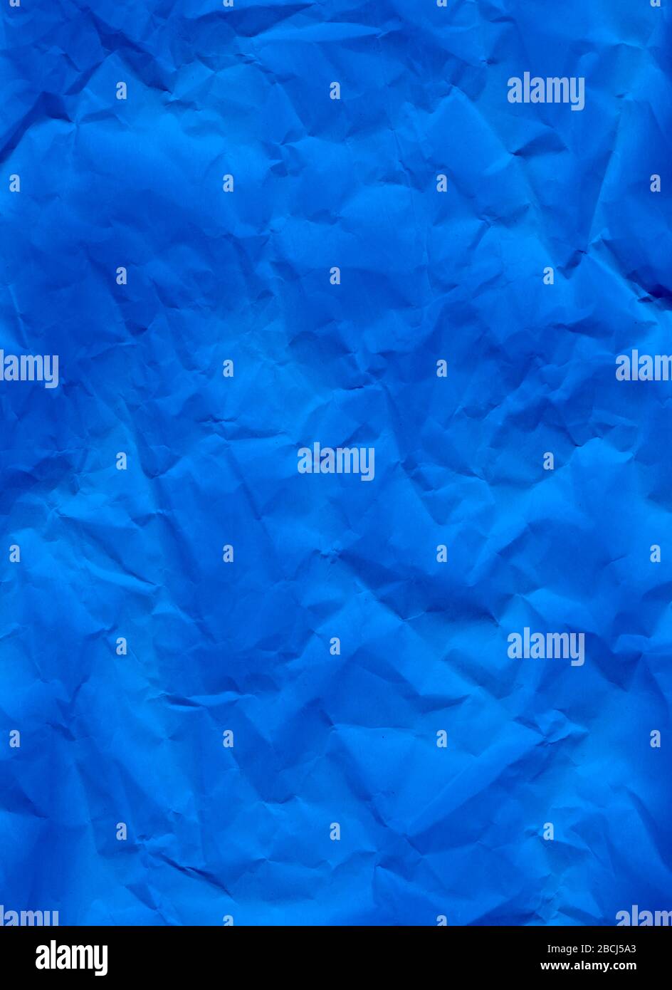 Hintergrund der blauen zerknitterten Papiertextur. Ein abstraktes Makrofoto aus der Nähe von zerknittertem Papier. Abstrakte Planlage, Draufsicht. Vertikales Format. Freier Speicherplatz für Stockfoto