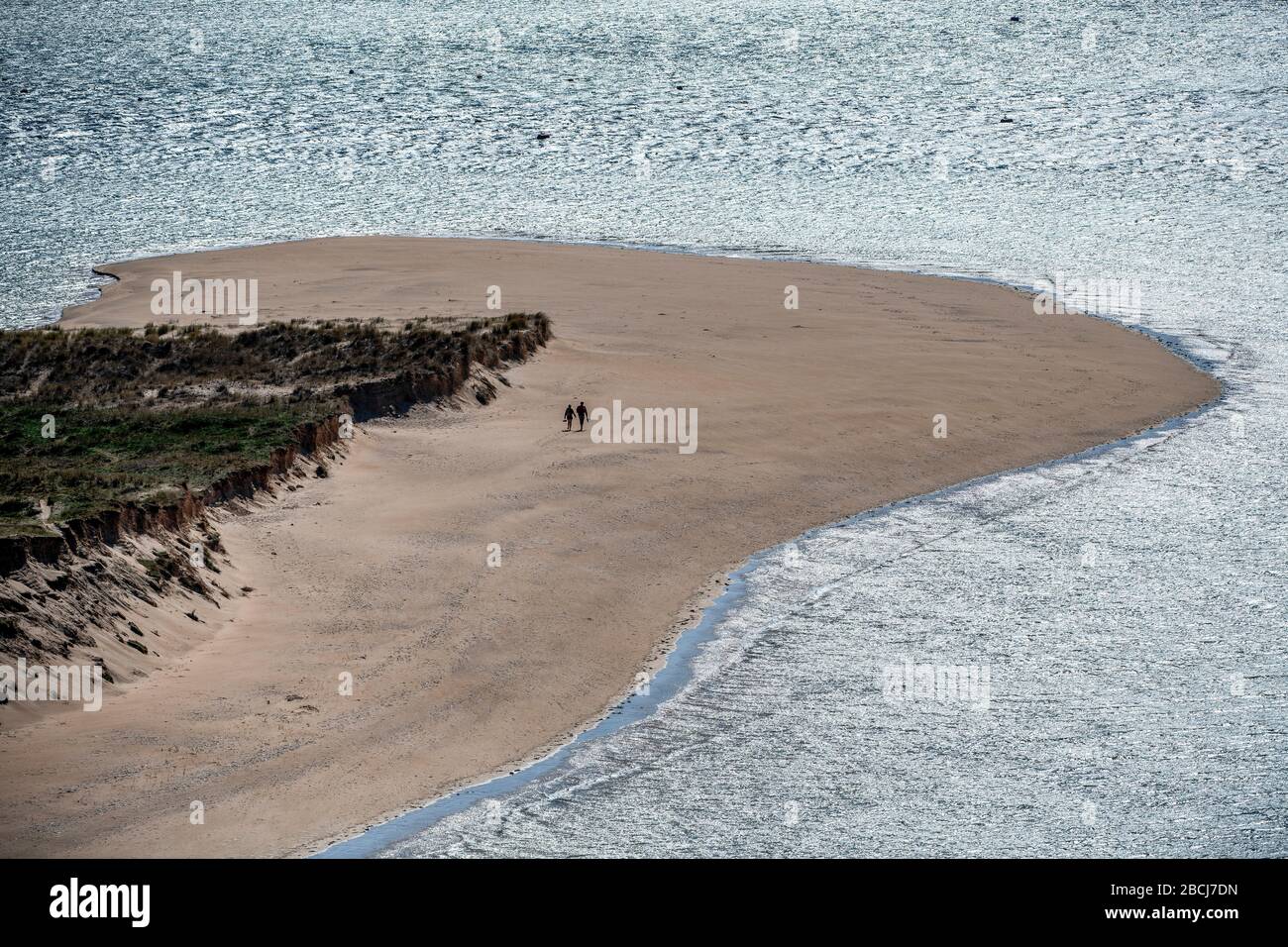 Ein Paar spazieren am einsamen Strand von Brae Hill in der Flusspromenade von Camel, Cornwall, da die Einschränkungen der Regierung weiterhin versuchen, das Coronavirus zu enthalten. Stockfoto