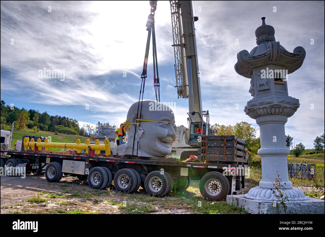 Die Verladung der Steinstatue per Kranwagen im Gebäude des Buddha Maitreya. Stockfoto