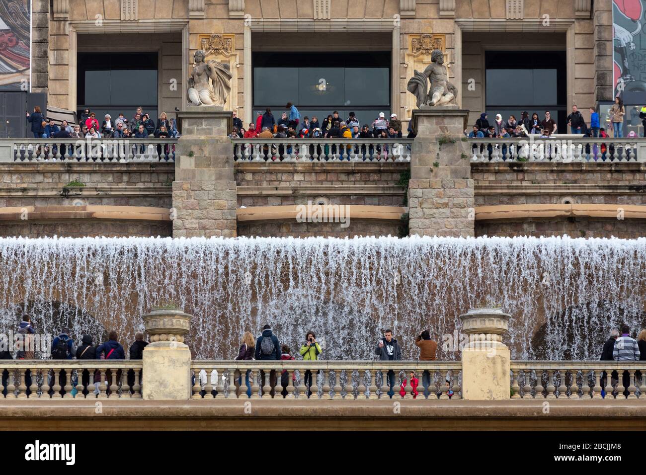 Menschen, die neben den künstlichen Wasserfällen in der Plaça de les Cascades in Barcelona, Spanien, stehen Stockfoto