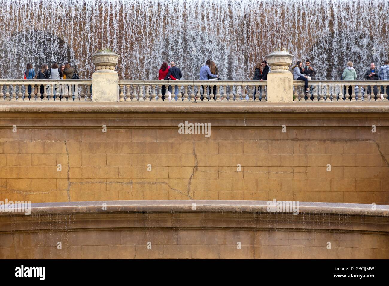 Menschen, die neben den künstlichen Wasserfällen in der Plaça de les Cascades in Barcelona, Spanien, stehen Stockfoto