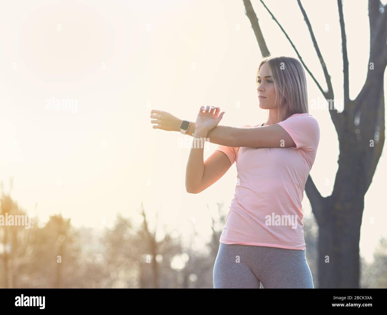 Junge sportliche Frau, die sich im Park Closeup ausdehnt Stockfoto