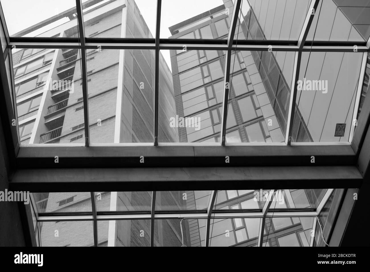 Modernes Apartmentgebäude mit Blick auf das Glasdach einer Lobby Stockfoto