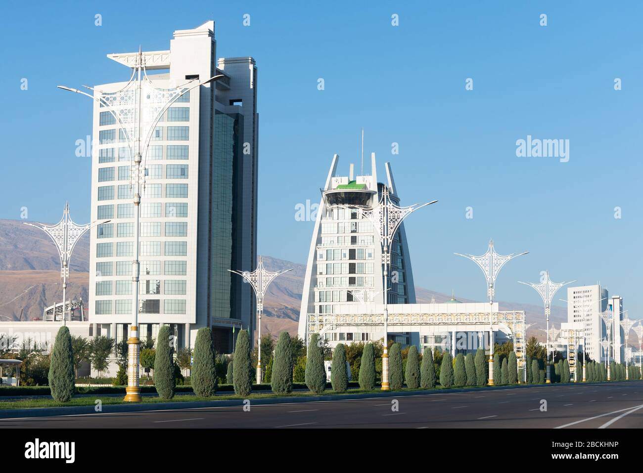 Ministerien Gebäude am Archabil Highway in Aschgabat, Turkmenistan, Regierung weißen Marmor Konstruktionen mit Vegetation und leere Allee. Stockfoto