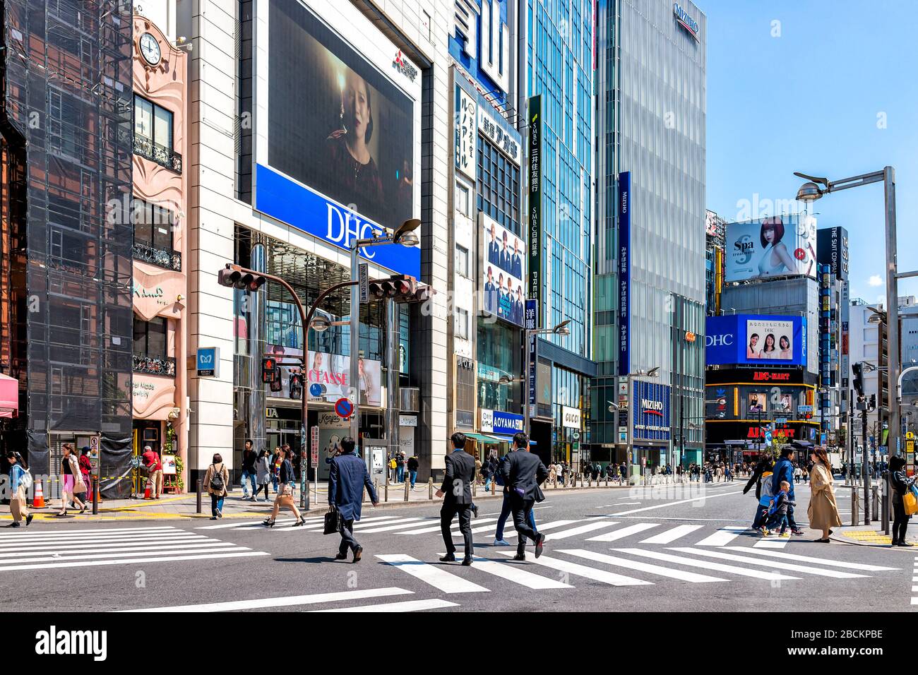 Tokio, Japan - 2. April 2019: Shinjuku Crosswalk mit Salaryman Business viele Menschen, die in der morgendlichen Hauptverkehrszeit die Straße überqueren, pendeln auf der Straße in der Nähe von Construs Stockfoto