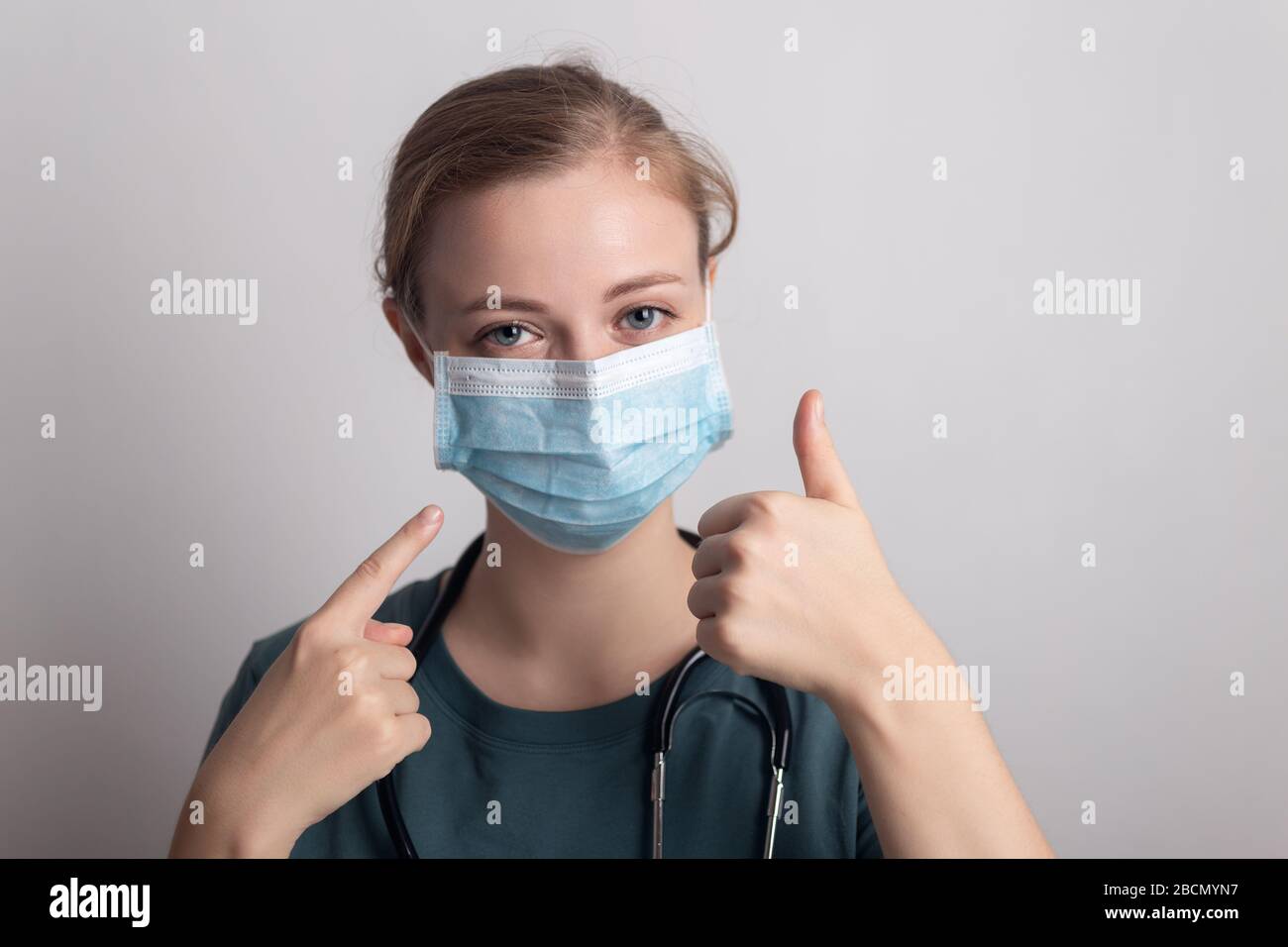 Weibliche kaukasische Arztschwester Frau mit chirurgischer Maske Stockfoto