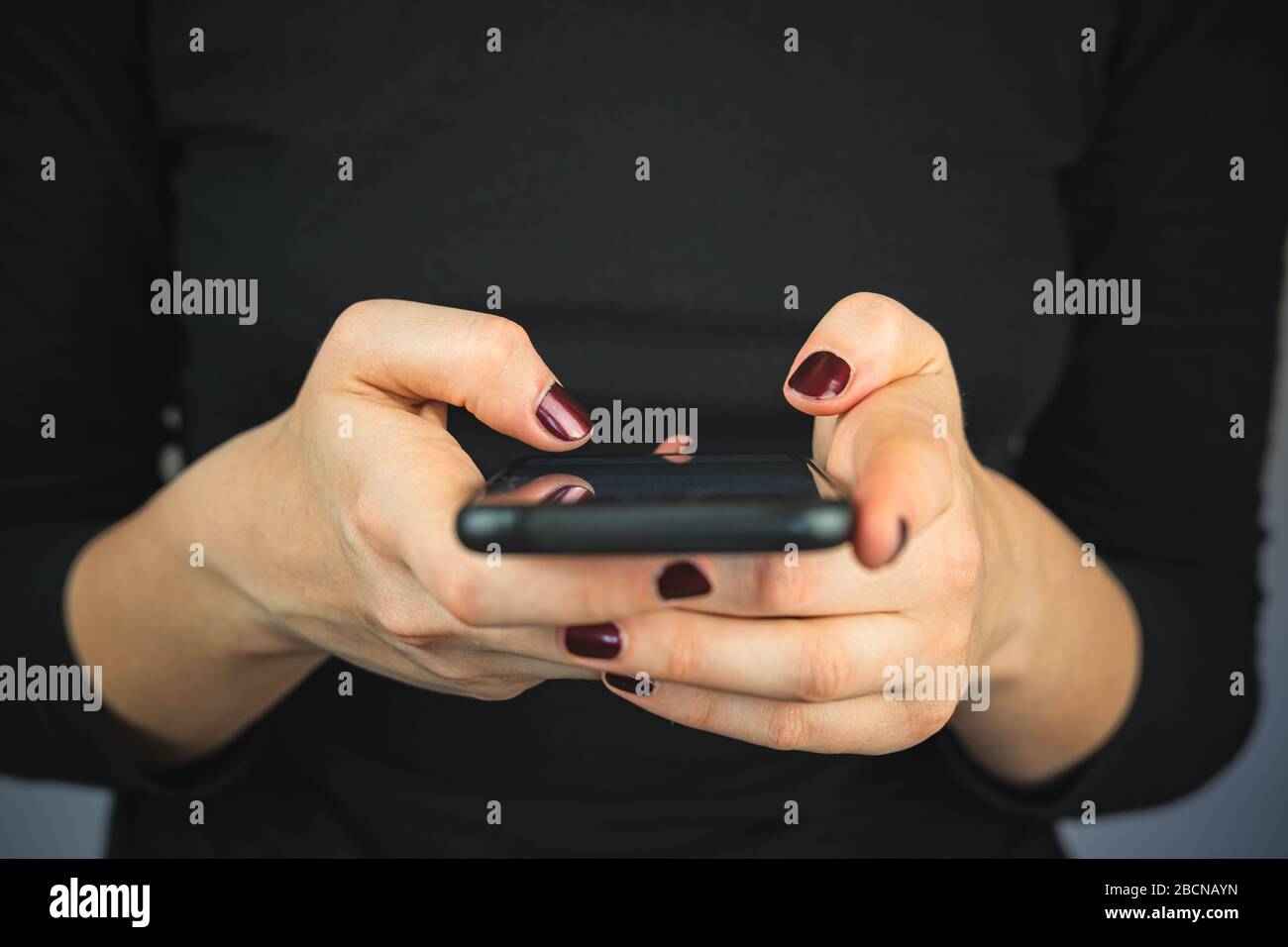 SMS über Smartphone auf dem Telefon. Weibliche Hände mit einem Smartphone, das Text eingibt und scrollt, Nahansicht Stockfoto