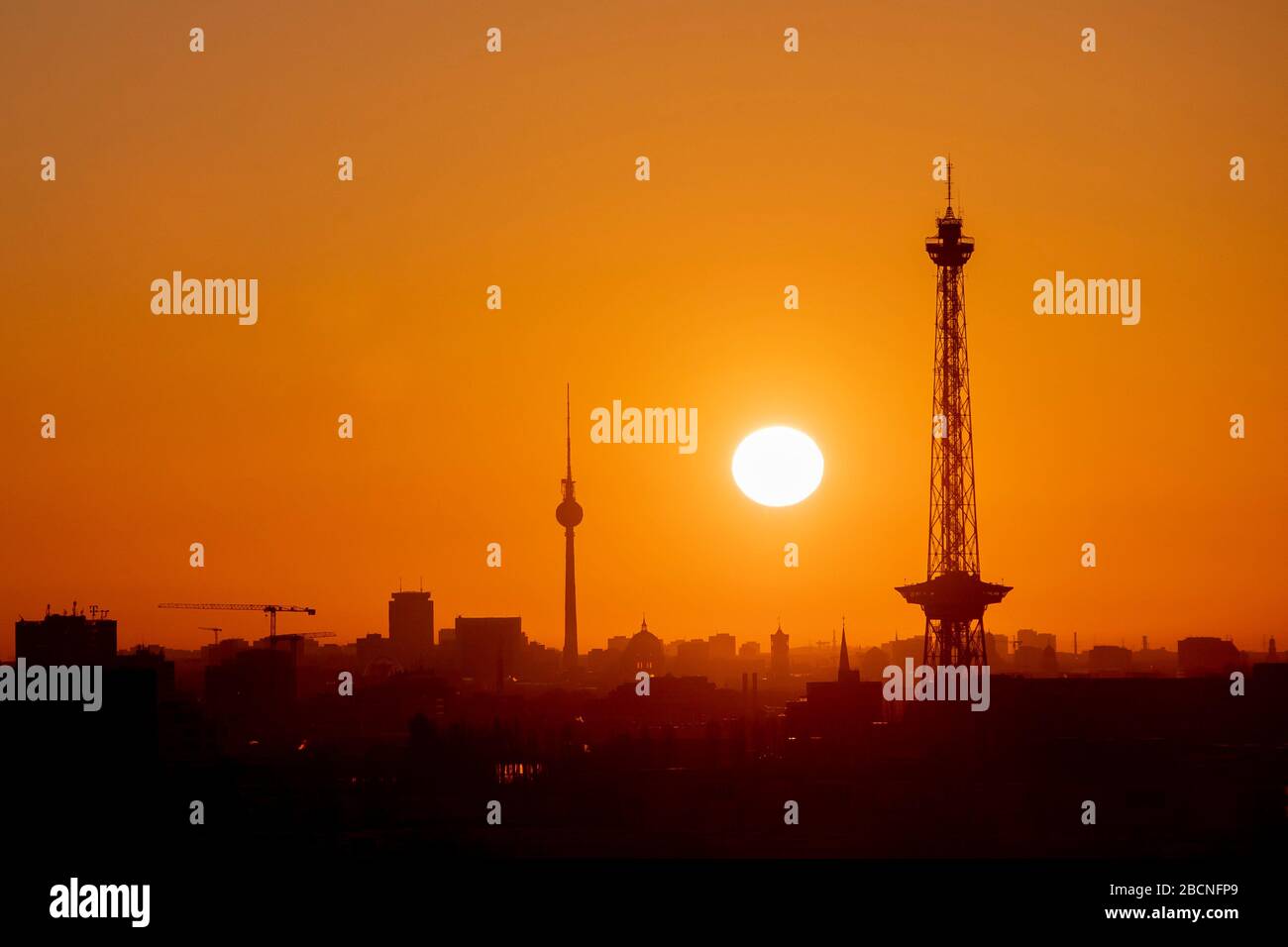 Berlin, Deutschland. April 2020. Die Sonne steigt vom Drachenberg aus über Berlin mit dem Fernsehturm und dem Funkturm. Credit: Christoph Soeder / dpa / Alamy Live News Stockfoto