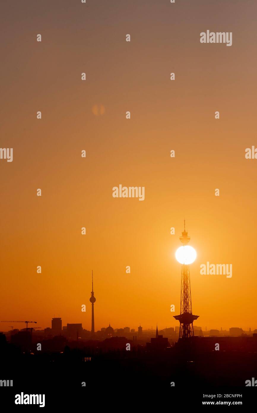Berlin, Deutschland. April 2020. Die Sonne steigt vom Drachenberg aus über Berlin mit dem Fernsehturm und dem Funkturm. Credit: Christoph Soeder / dpa / Alamy Live News Stockfoto