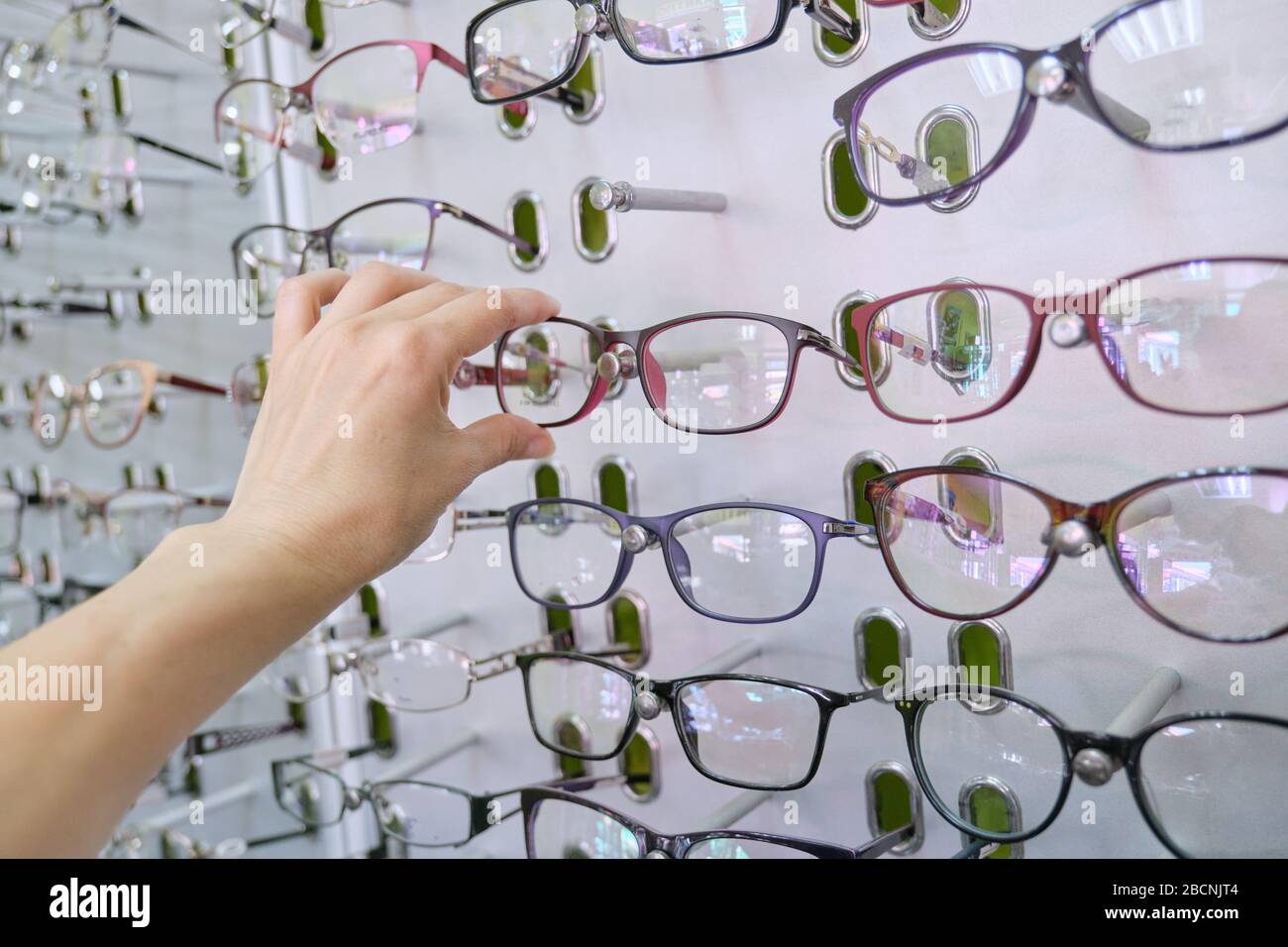 Zeigen Sie mit einer Brille im Laden, und wählen Sie eine Brille aus der Hand Stockfoto