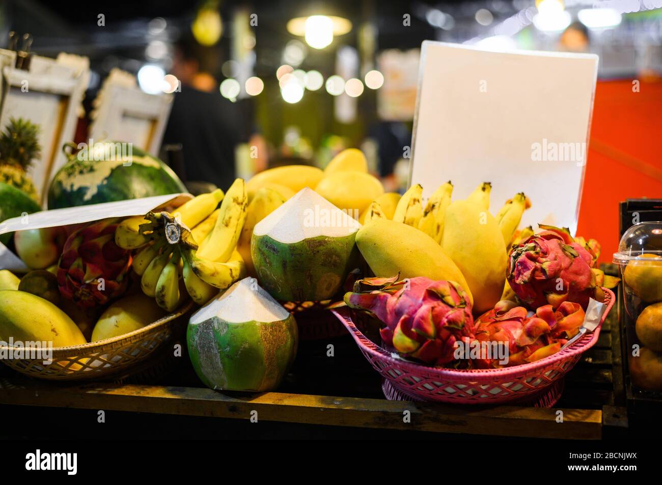 Tropische thailändische Früchte stehen auf dem lokalen Lebensmittelmarkt in Thailand. Kokosnuss, Libelle, Banane und Mango am Abend fair. Stockfoto