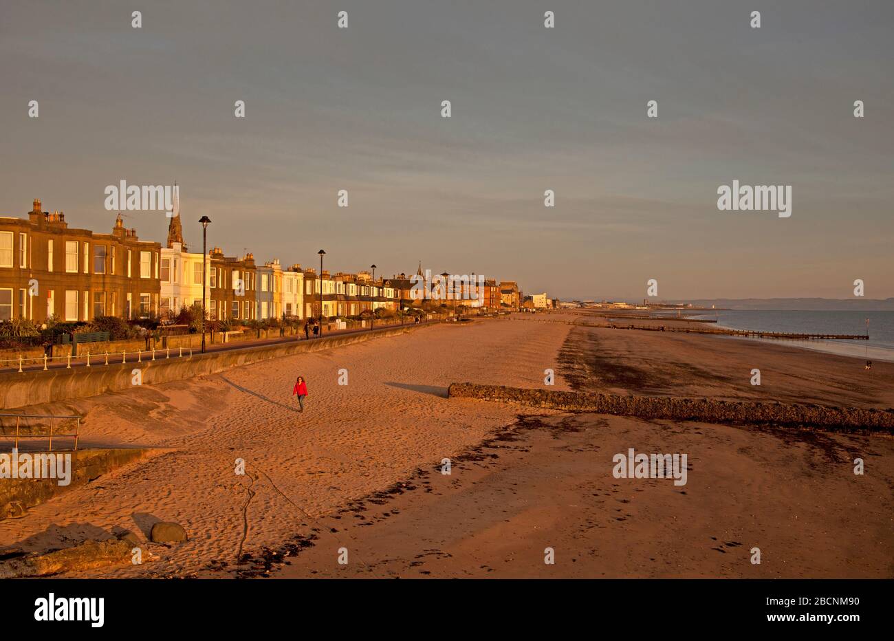 Portobello, Edinburgh, Schottland, Großbritannien. April 2020. Sonnenaufgang am Portobello Beach, mit verschiedenen Menschen, die auf dem Sandstrand spazieren, schwimmen, laufen und sitzen. Mit leeren Bänken und im Hintergrund ein Foto von der Fotoanzeige "Into the Blue" vom Wissenschaftsfestival 2020, das nie stattfand und der Aqua 1 Seemannsfahrt zugeschrieben wird, Es fotografiert eine Kreuzform aus Muscheln aus dem Meer, die auf dieser zweiten Woche des Covid-19 Coronavirus Sperrens in Großbritannien ergreifend wirkt. Stockfoto