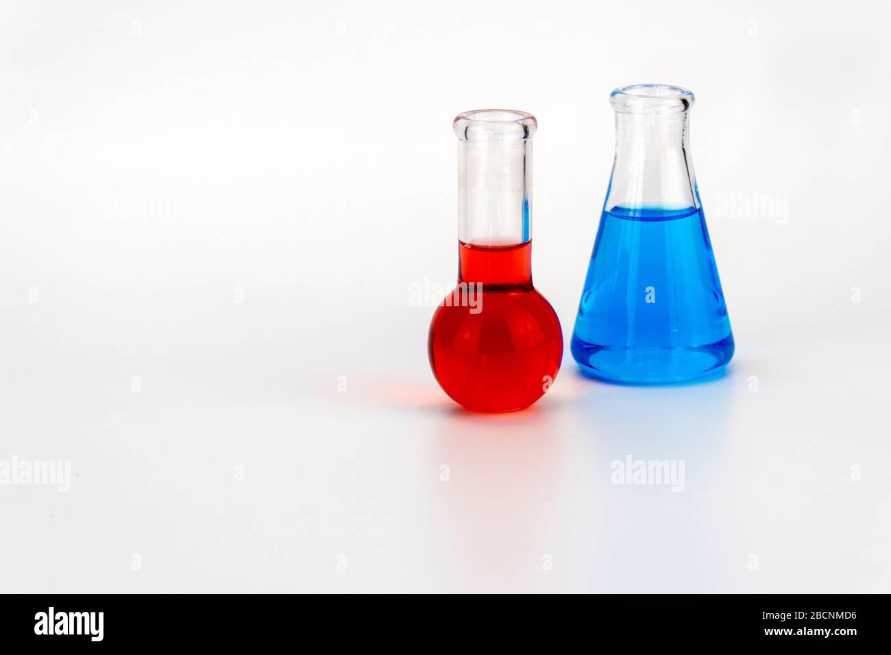 Laborglas mit Flüssigkeit auf weißem Hintergrund. Glaskolben mit Reagenz. Stockfoto
