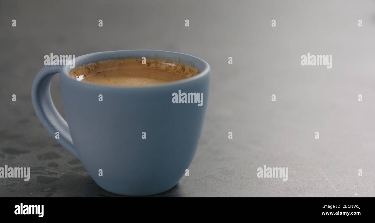 Blaue Tasse mit frischem Espresso auf Betonoberfläche Stockfoto