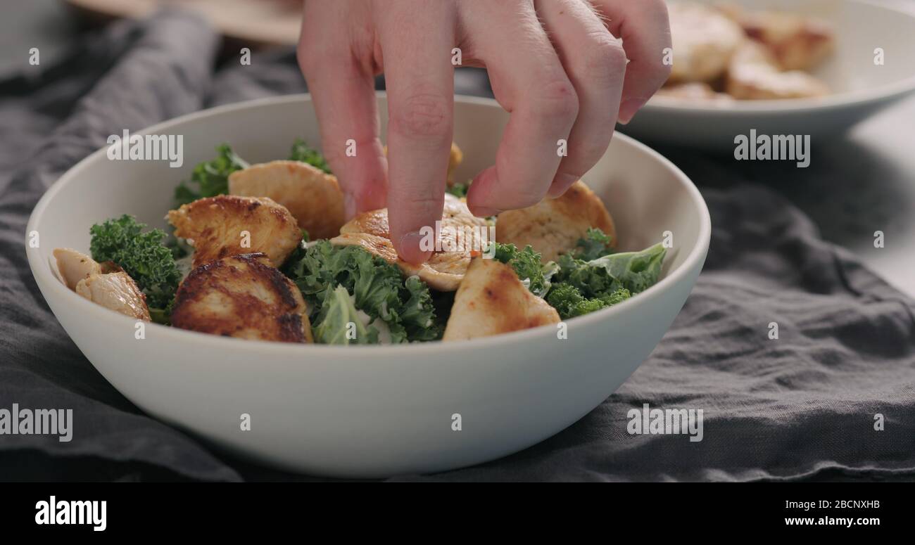 Mann Hände caesar Salat mit Grünkohl und truthahn in einer weißen Schüssel, fügen sie pute Stockfoto