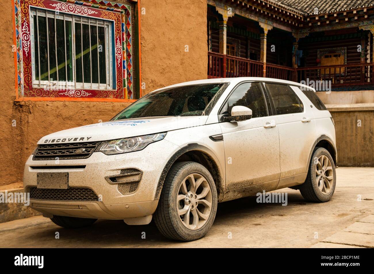 Land Rover Discovery Sport parkte außerhalb eines Gebäudes im tibetischen Stil in Malong Village, Provinz Sichuan, China. Stockfoto