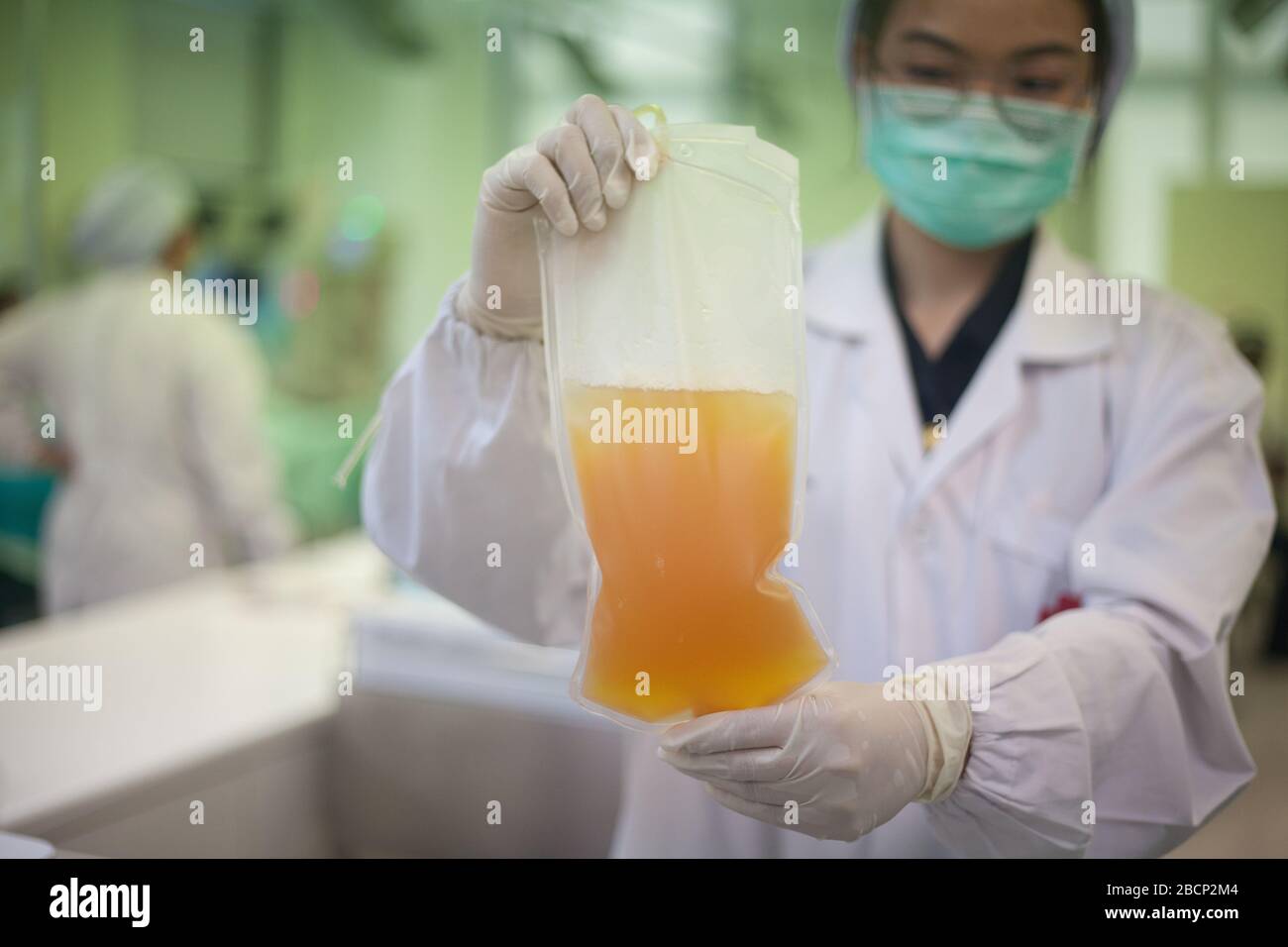 Bangkok, Thailand. April 2020. Eine Krankenschwester trägt eine Schutzmaske, in der ein Plasmablutbeutel eines Spenders der thailändischen Gesellschaft des Roten Kreuzes angebracht ist. Das thailändische Rote Kreuz hat darum gebeten, Plasmablut von dem Patienten zu spenden, der von COVID-19 geborgen wurde. Credit: SOPA Images Limited/Alamy Live News Stockfoto