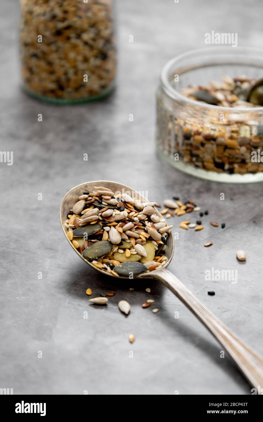 Gesunde Samen vermischen sich in einem Holzlöffel aus der Nähe. Gesunde Lebensmittel, vegane Lebensmittelzutaten Stockfoto