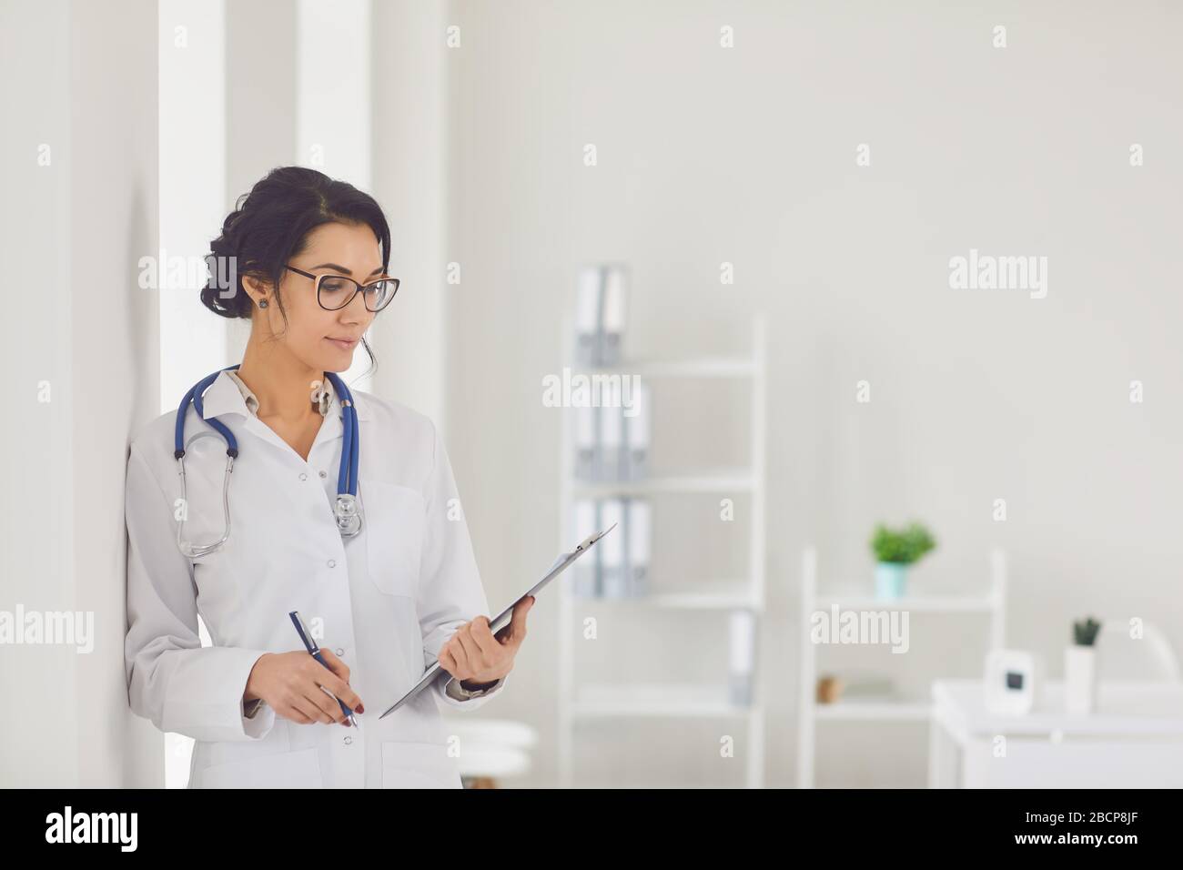 Frau Ärztin Kinderärztin steht im weißen Büro des Krankenhauses. Stockfoto