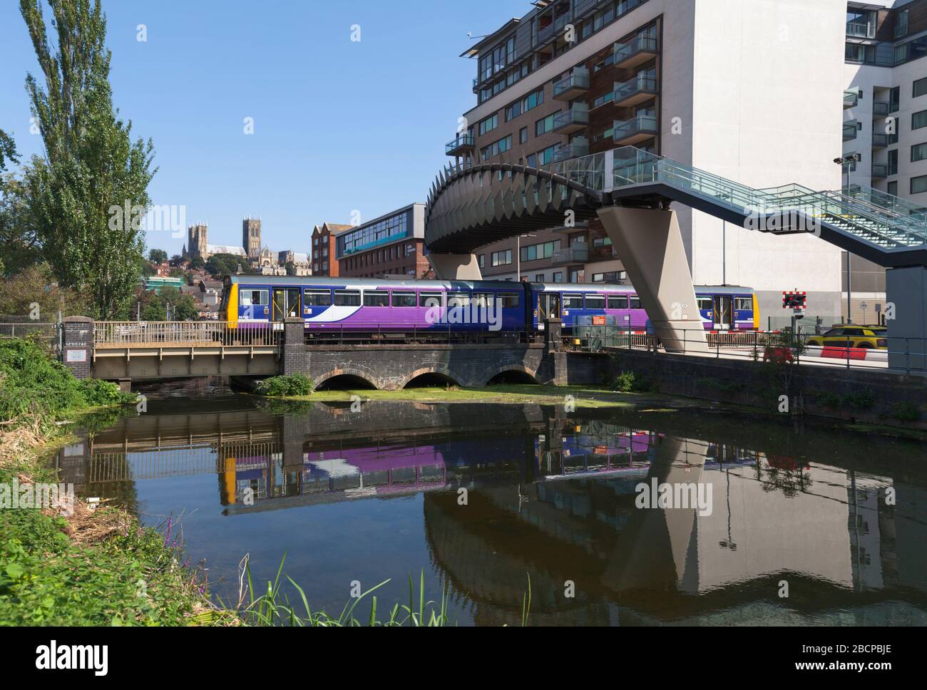 Northern Rail Class 142 Pacer Train 142092 Abfahrt Lincoln spiegelte sich im Fluss mit Lincoln Kathedrale im Hintergrund. Stockfoto