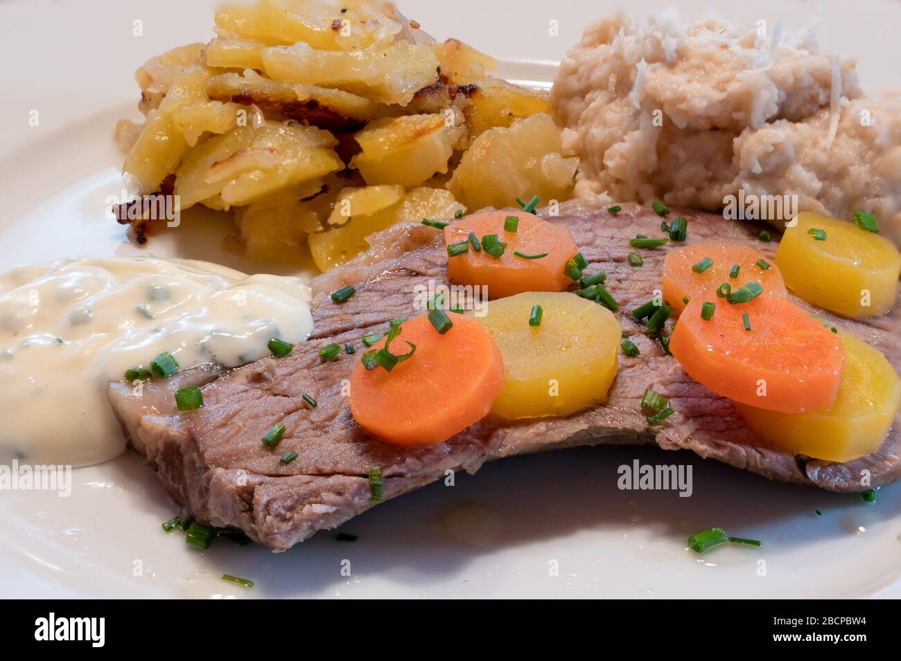Wiener Prime Boiled Beef Tafelspitz mit traditionellen Seiten von Schnittlensauce, Wiener Kartoffeln, Brot-Horseradisch und Karotten Stockfoto