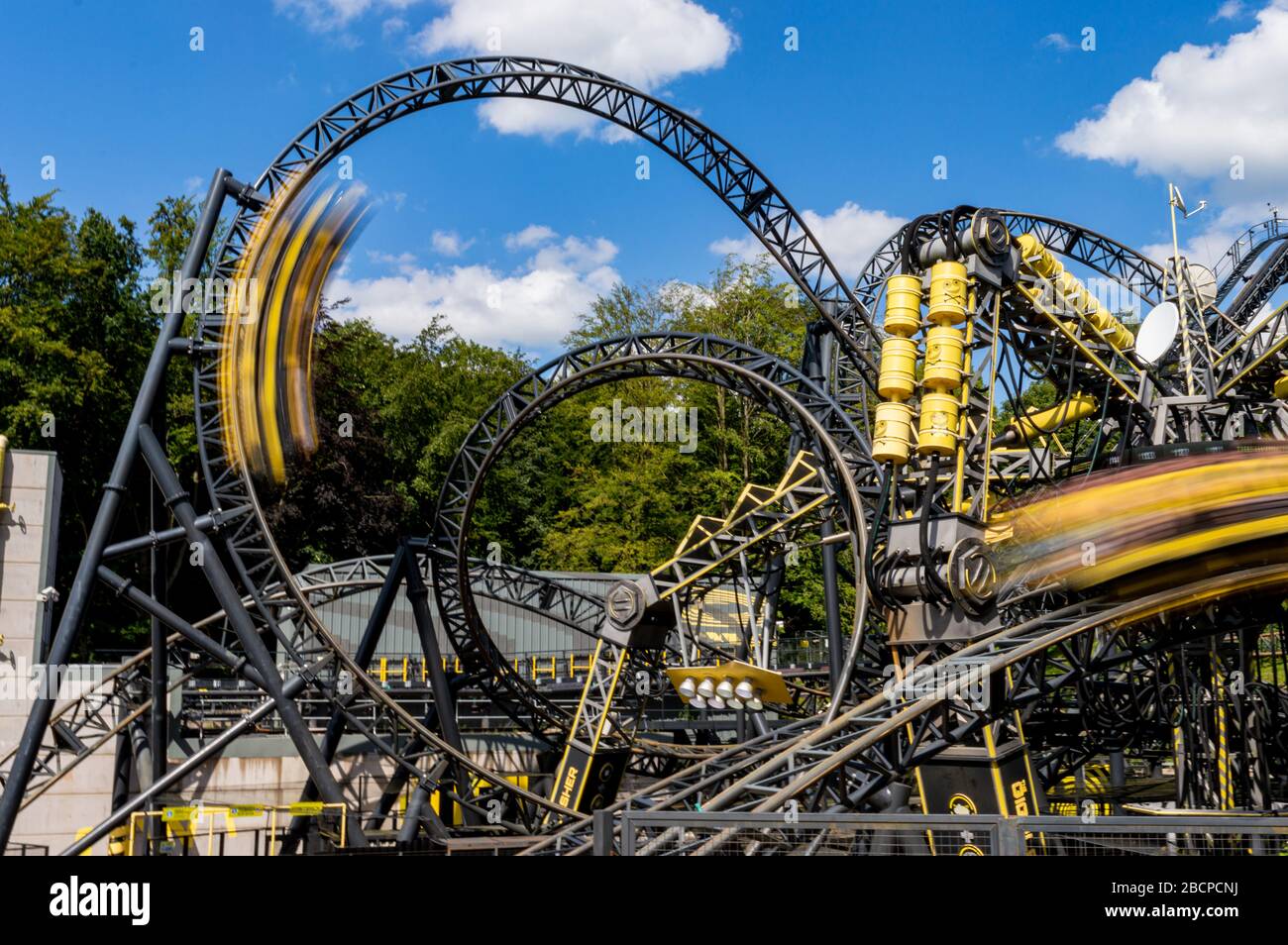 The Smiler im Alton Towers Theme Park, Großbritannien. Gelbe Autos fliegen um die Strecke, die Weltrekord 14 Inversionen hat. 3 Minuten lang mit einem vertikalen Hub Stockfoto