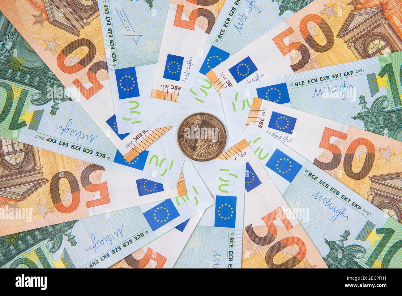 Hintergrund aus Euro-Banknoten und Dollarmünze mit Freiheitsstatue Stockfoto