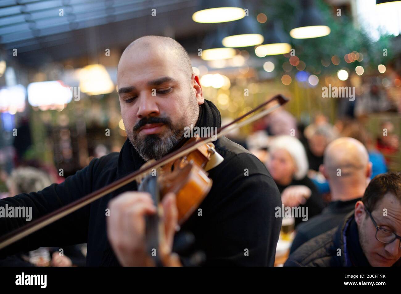 Ein Fiddler spielt im Winter einem Restaurantpublikum in der Central Market Hall, Budapest, Ungarn Stockfoto