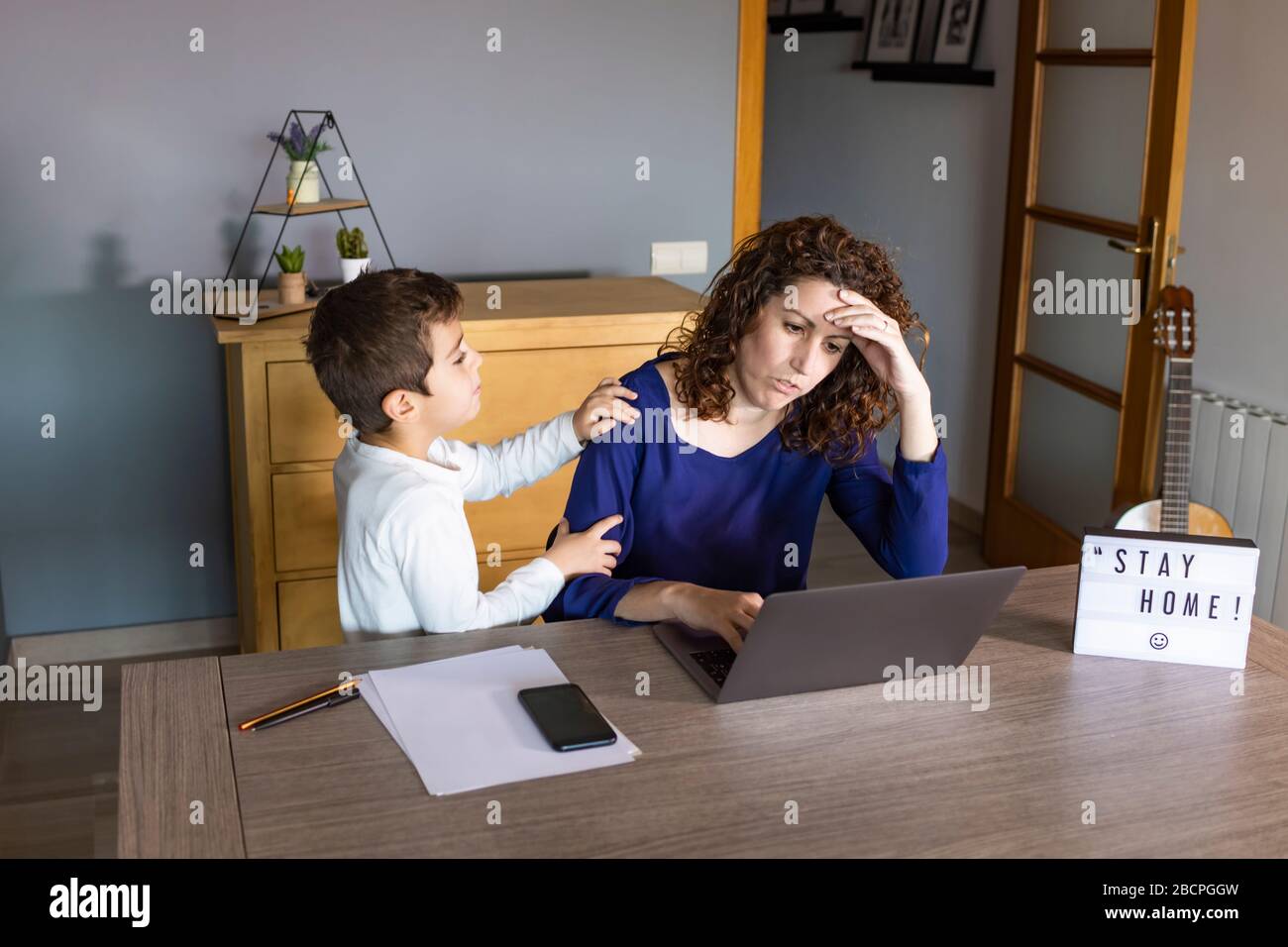 Mutter, die mit einem Kind von zu Hause aus arbeitet. Quarantänemodus Stockfoto