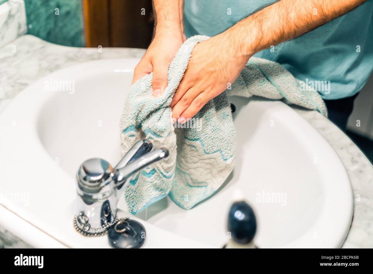 Trocknen Sie Ihre Hände mit einem Handtuch, nachdem Sie sie gut waschen, um Coronavirus-Infektion Reflexion eines Spiegels zu verhindern. Stockfoto
