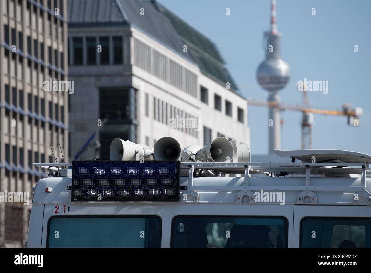 Berlin, Deutschland. April 2020. Die Formulierung "gemeinsam gegen Corona" ist auf einem Polizeifahrzeug in Sichtweite des Fernsehturms zu sehen. Die Polizei war an verschiedenen Orten unterwegs, um die Einhaltung der Vorschriften zur Eindämmung des Corona-Virus zu überprüfen. Kredit: Jörg Carstensen / dpa / Alamy Live News Stockfoto