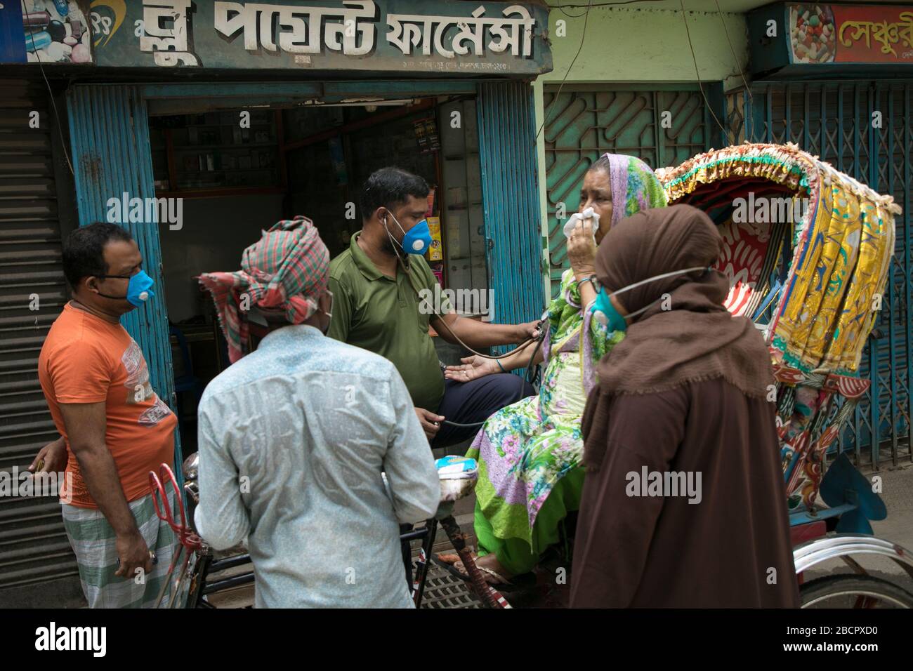 Dhaka, Bangladesch. April 2020. Eine Patientin, die ihren Blutdruck auf der Straße, vor einer Apotheke in Old Dhaka während der von der Regierung verhängten Sperre als präventive Maßnahme gegen das COVID-19-Coronavirus in Dhaka, Bangladesch am 05. April 2020 zählt. Kredit: Zakir Hossain Chowdhury/ZUMA Wire/Alamy Live News Stockfoto
