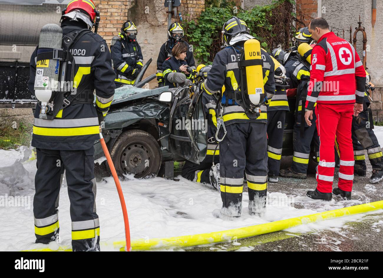 Feuerwehrleute retten eingeklemmten Fahrer während einer Unfallsimulation mit Autos, Zug und Lastwagen. Feuerwehrleute mit Atemschutzgerät und Hyd Stockfoto