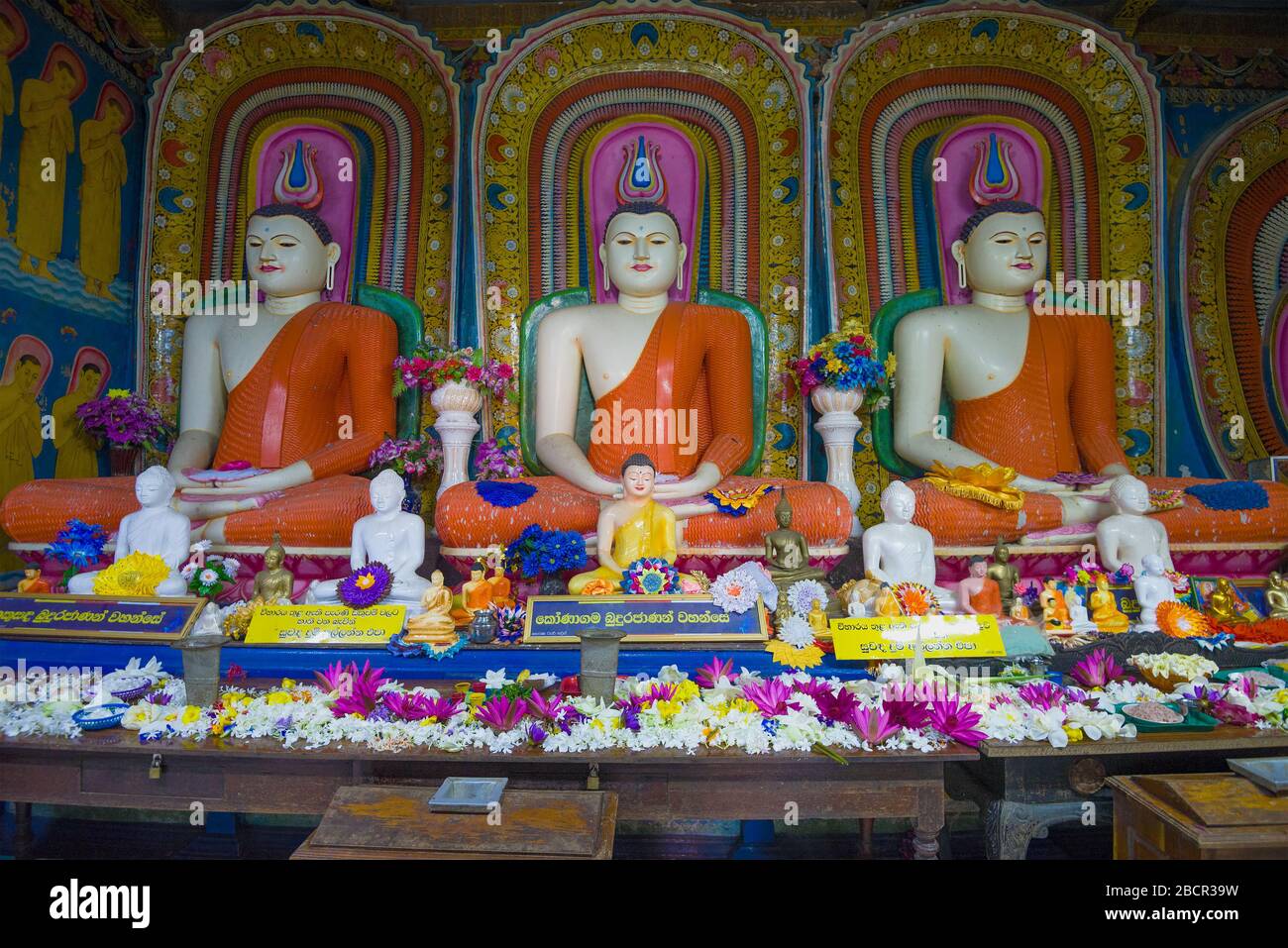ALUTHAMA, SRI LANKA - 16. FEBRUAR 2020: Drei Skulpturen eines sitzenden Buddha auf dem Altar des alten buddhistischen Tempels Kande Viharaya Stockfoto