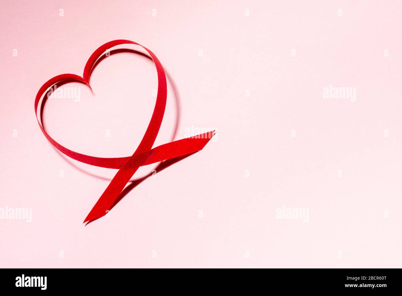 Rote Papier-Herzform auf pinkfarbenem Hintergrund mit Kopierraum, Valentinstag- und Muttertagskarte, Liebeskonzept Stockfoto