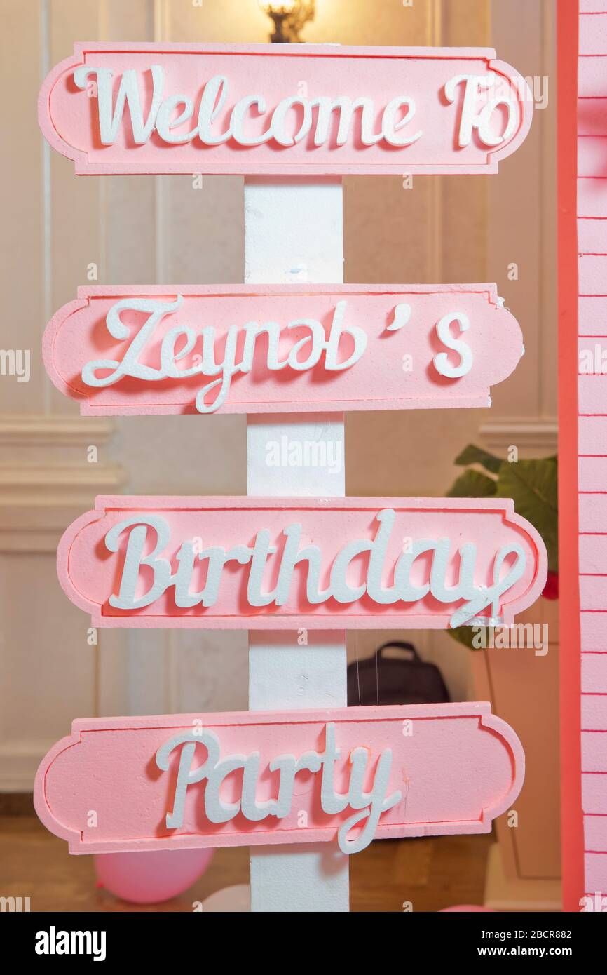 Nummer eins auf violettem Hintergrund . Das Kind ist pink gekleidet. Geburtstag eines alten Kindes . Welkome zu Zeynebs Birthdays Party. Baku, Aserbaidschan. 16 Stockfoto