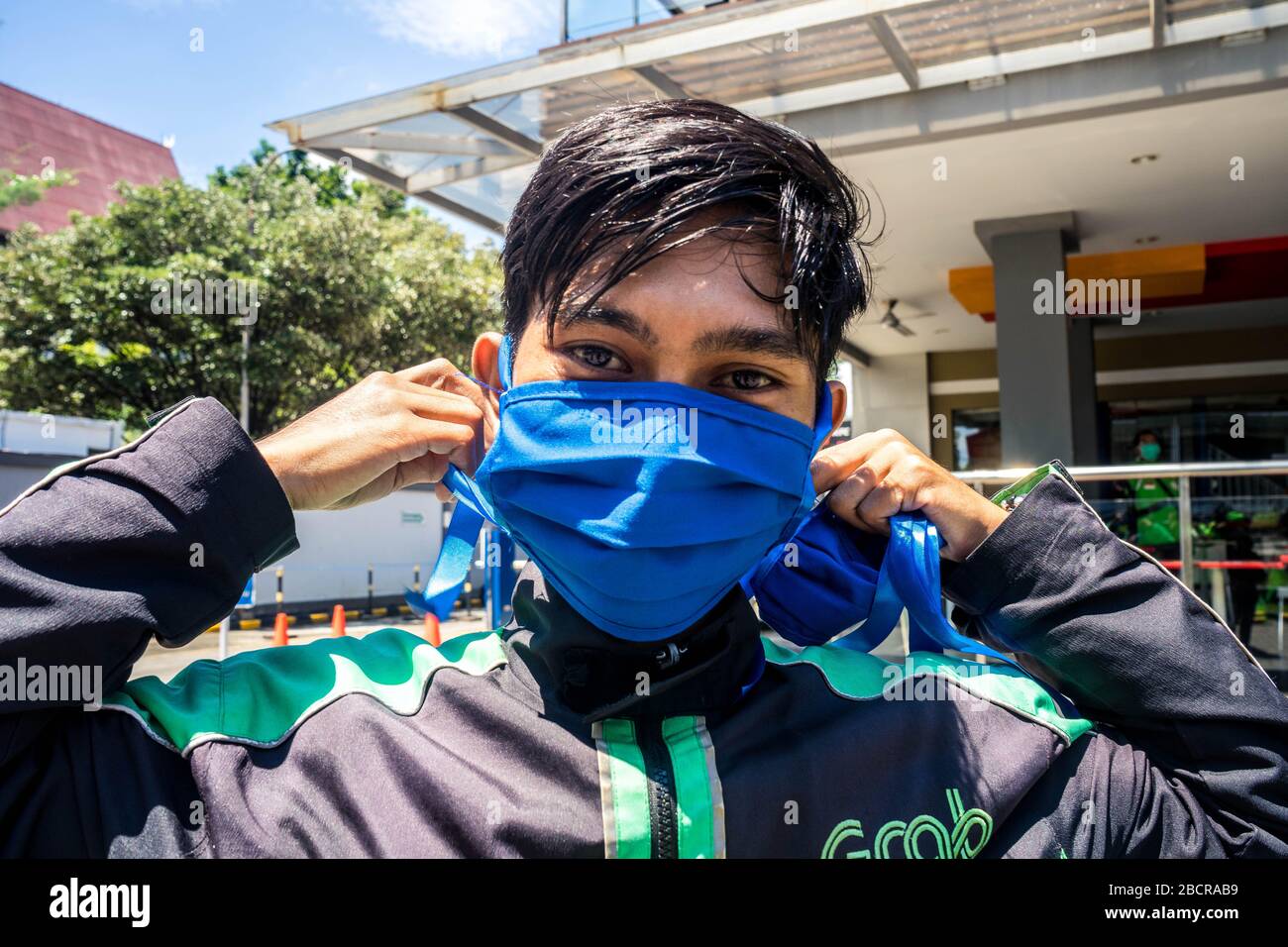 Makassar, Süd-Sulawesi, Indonesien. April 2020. Ein Online-Fahrer trägt seine Stoffmaske, um sie bei der Arbeit auf der Straße zu verwenden, die Passagiere in Makassar City, Provinz South Sulawesi, Indonesien abliefert. Diese Stoffmaske musste verwendet werden, um die Ausbreitung von Coronavirus (Covid-19) zu verhindern, da der Bestand an medizinischen Standardmasken auf dem Markt stark reduziert wurde. Gutschrift: Herwin Bahar/ZUMA Wire/Alamy Live News Stockfoto