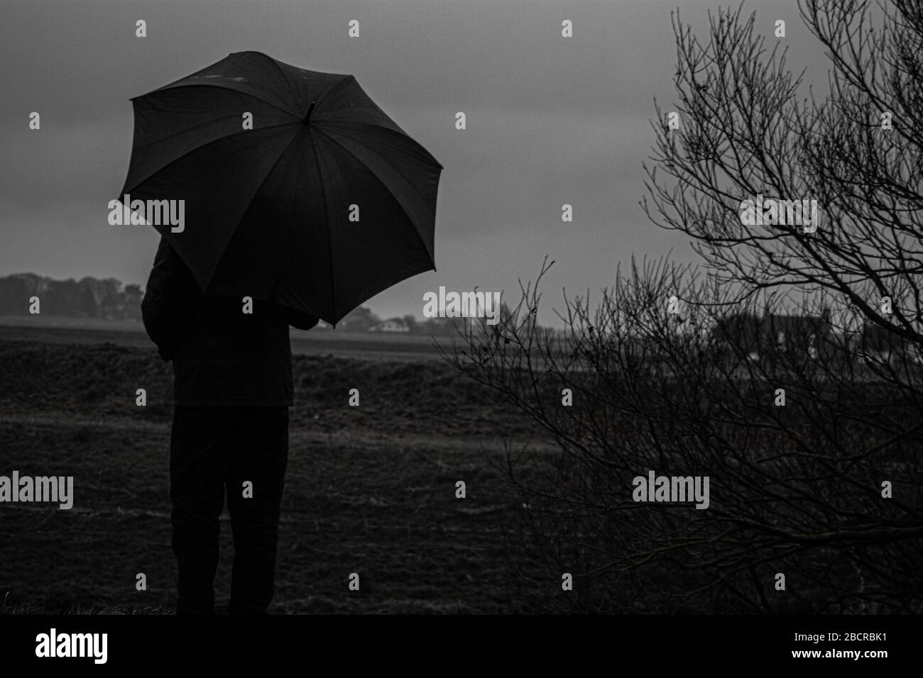 Ein intensiver altmodischer Schuss in Schwarz und Weiß mit Regenschirm Stockfoto
