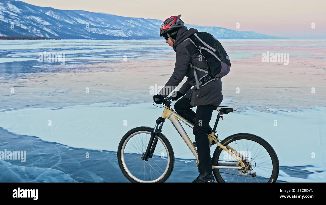 Der Mann fährt mit dem Fahrrad auf dem Eis. Eis des gefrorenen Baikalsee. T-Stück Stockfoto