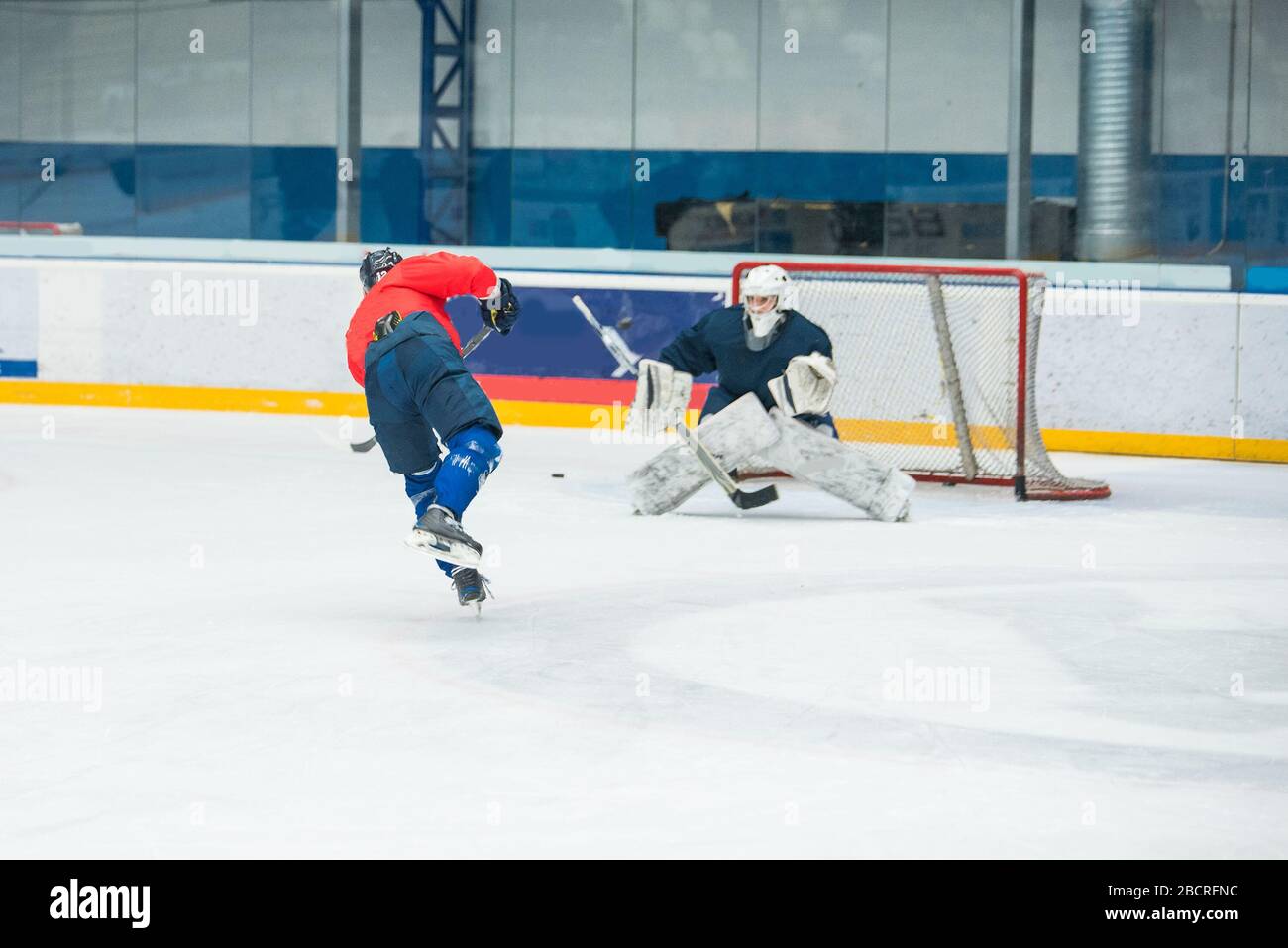 Eishockeyspieler und -Torwart auf dem Eis, Trainingsfoto Stockfoto