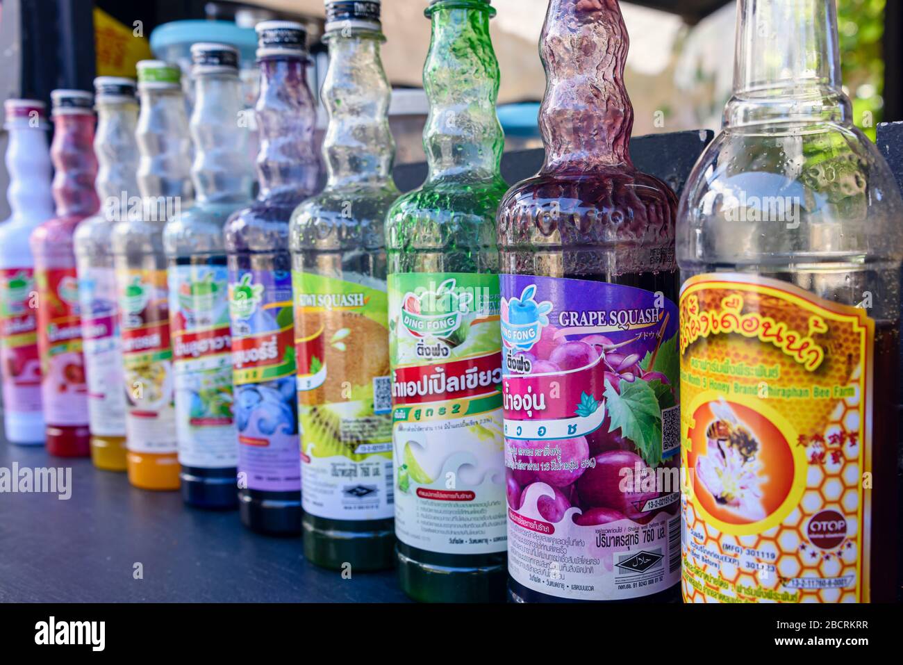 Flaschen aromatisierter Sirupe in einem Straßencafé zum Herstellen von Milchshakes und zerdrückten Eisgetränken, Kata Beach, Phuket, Thailand Stockfoto