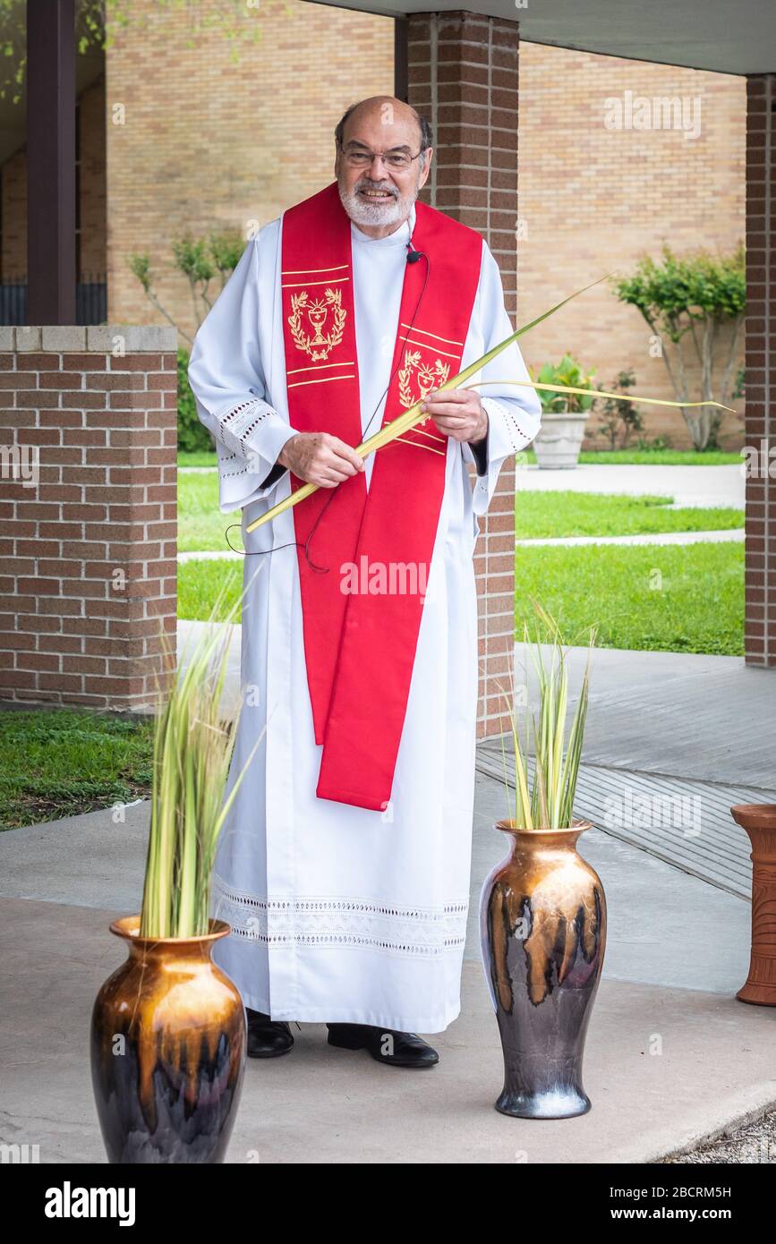 Houston, Texas, USA. April 2020. Pater TOM SMITHSON begrüßt die Gemeindemitglieder, da er an der Verteilung von Palmen in einem Drive-by-Vertrieb am Palmsonntag in der Corpus Christi Catholic Church Sunday, 5. April 2020, in Houston, Texas teilnimmt. Gutschrift: Lynn Pennington/ZUMA Wire/Alamy Live News Stockfoto