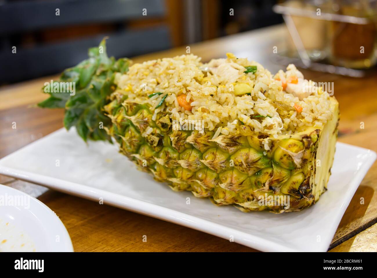 Gebratener Reis wird in einer ausgehöhlten Ananas in einem Restaurant in Thailand serviert. Stockfoto