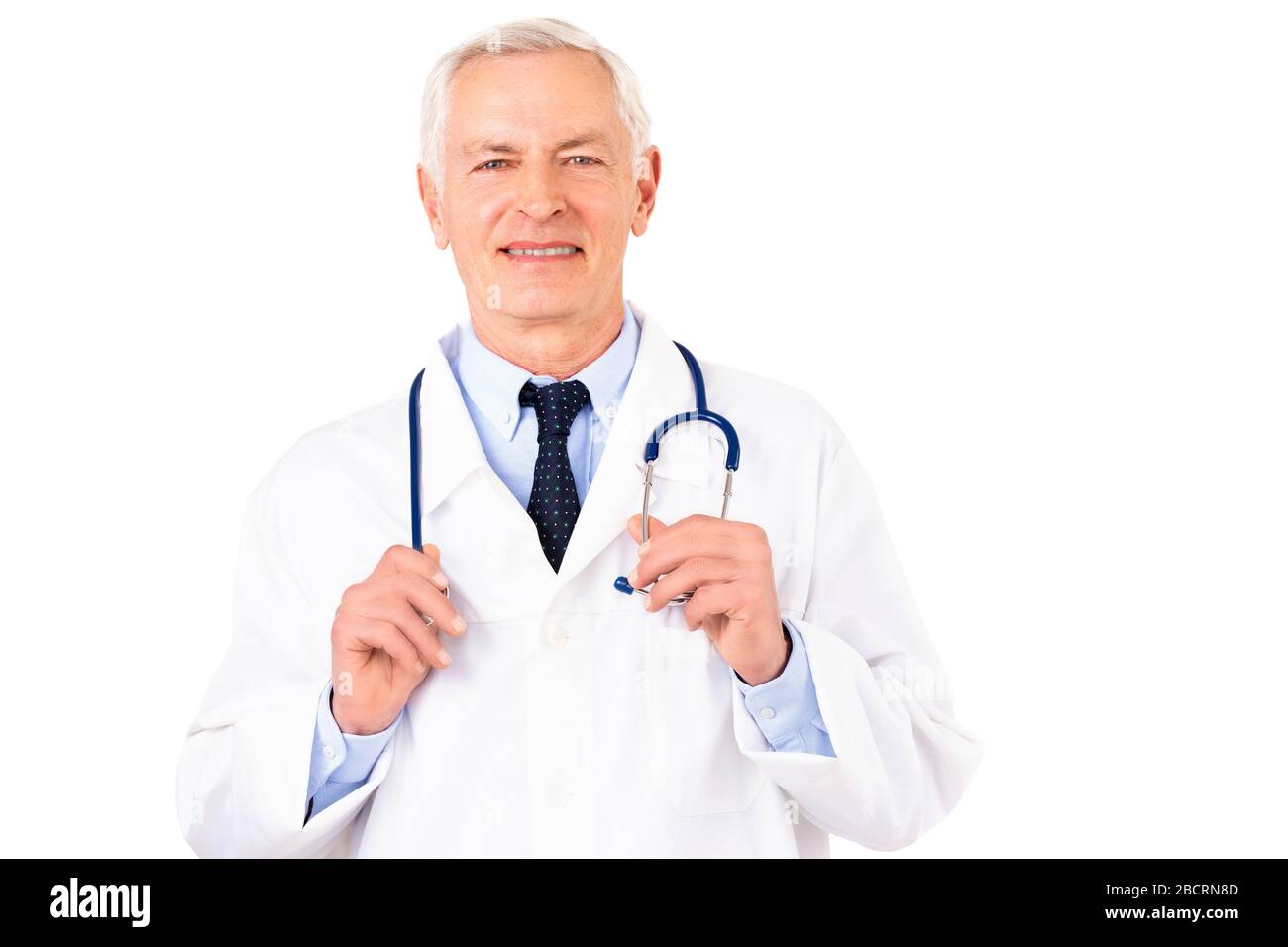 Portraitaufnahme eines männlichen Oberarztes mit Stethoskop um den Hals mit Uniform, während er auf isoliertem weißem Hintergrund steht. Stockfoto