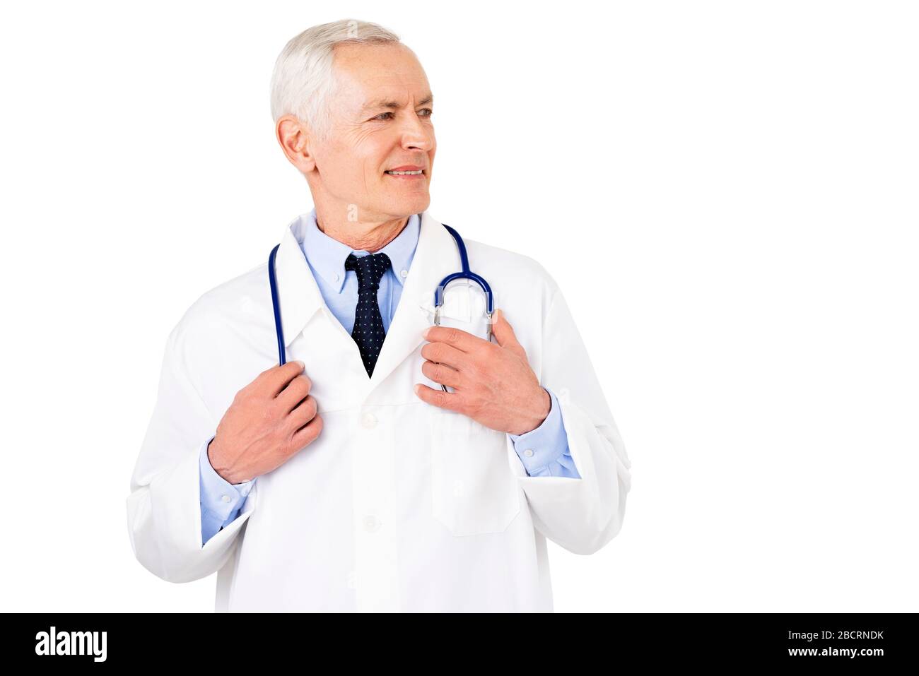 Portraitaufnahme eines männlichen Oberarztes mit Stethoskop um den Hals mit Uniform, während er auf isoliertem weißem Hintergrund steht. Stockfoto