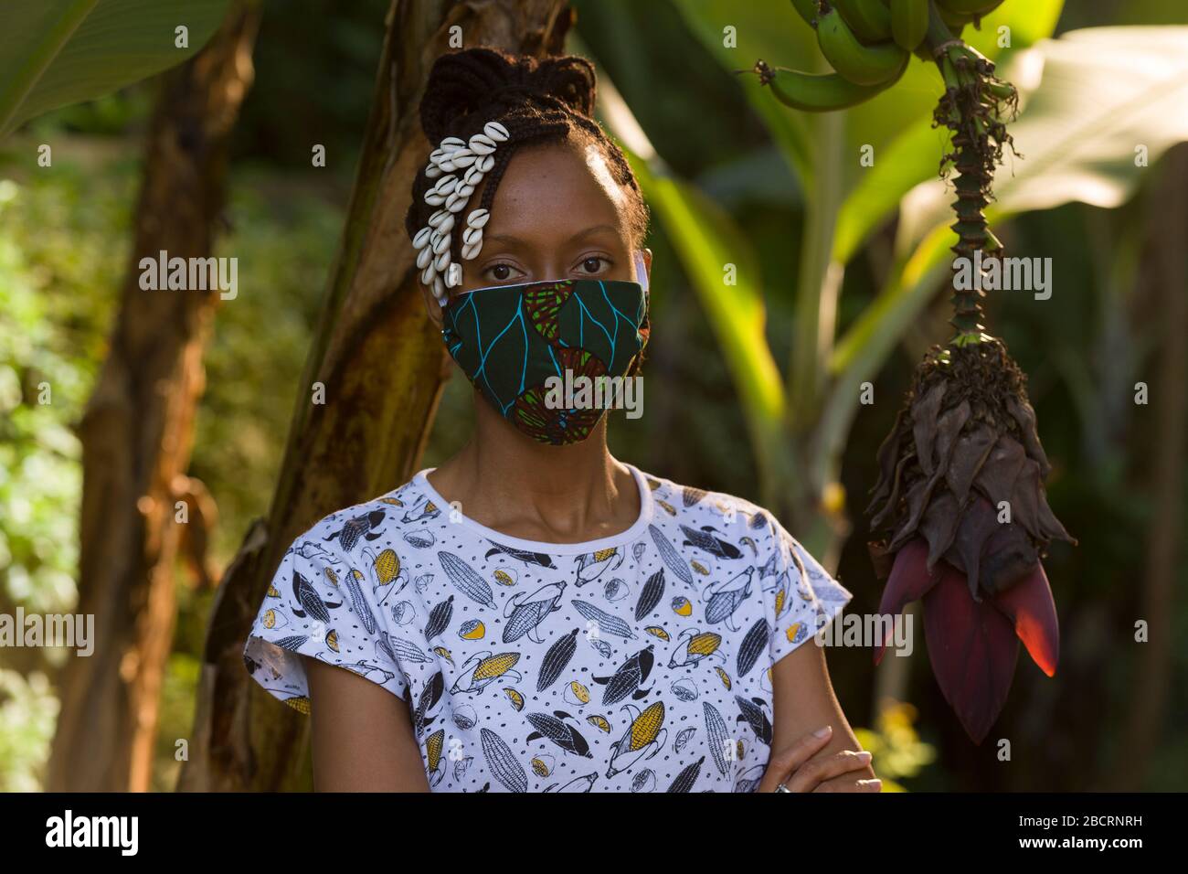 Eine kenianische Frau, die eine hausgemachte Maske trägt, aus traditionellem Kanga-Stoff zum Schutz vor einer Kovid-19-Pandemie. Chirurgische Masken befinden sich in kurzer Sup Stockfoto