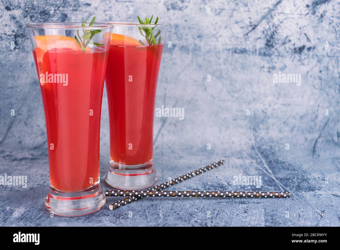 Zwei Gläser mit Grapefruitsaft auf grauem Hintergrund. Kopierbereich. Stockfoto
