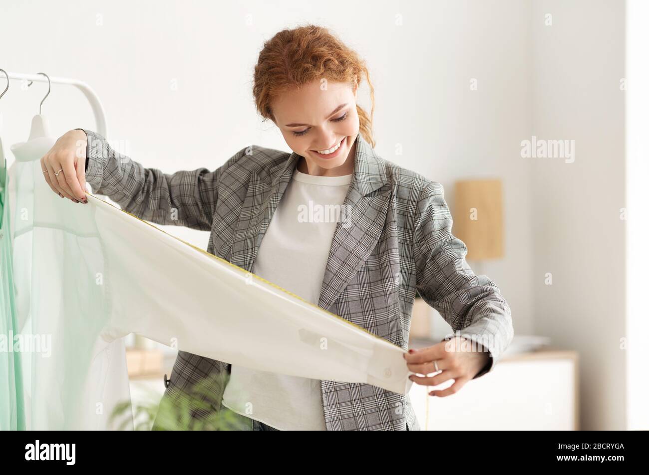 Dressmaker Measuring New Clothing Collection Im Showroom Stockfoto